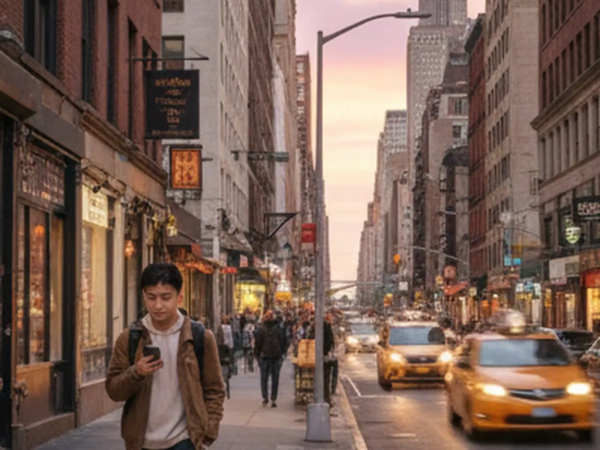 Golden-hour street scene in Midtown Manhattan with a young adult walking past brownstone stoops and small restaurants, checking directions on their phone, city lights just starting to glow, taxis and buses in soft motion blur, and the skyline visible in the distance.