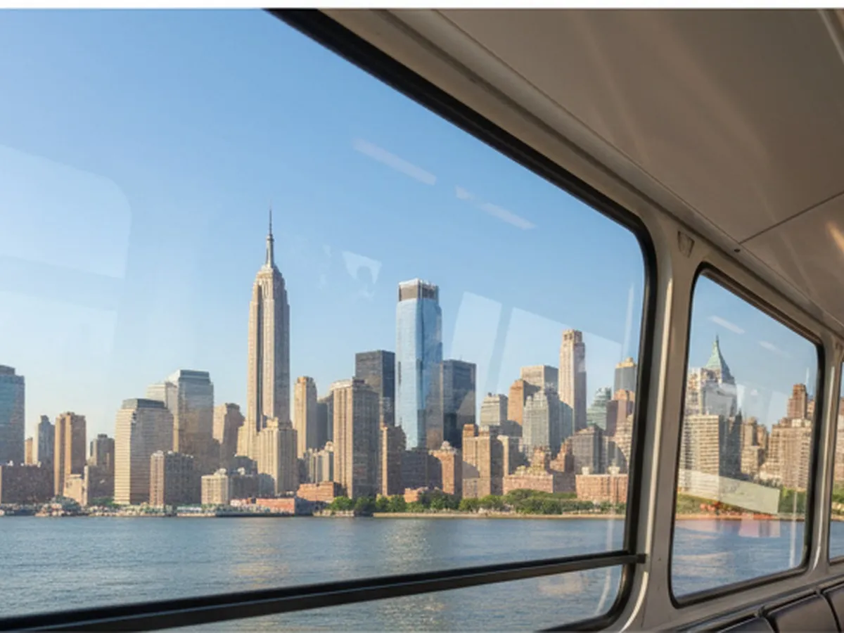 A bright summer afternoon view from inside a suspended NYC tram car crossing the East River, with Manhattan skyscrapers on one side, the Roosevelt Island shoreline below, and soft reflections on the glass, photorealistic editorial style.