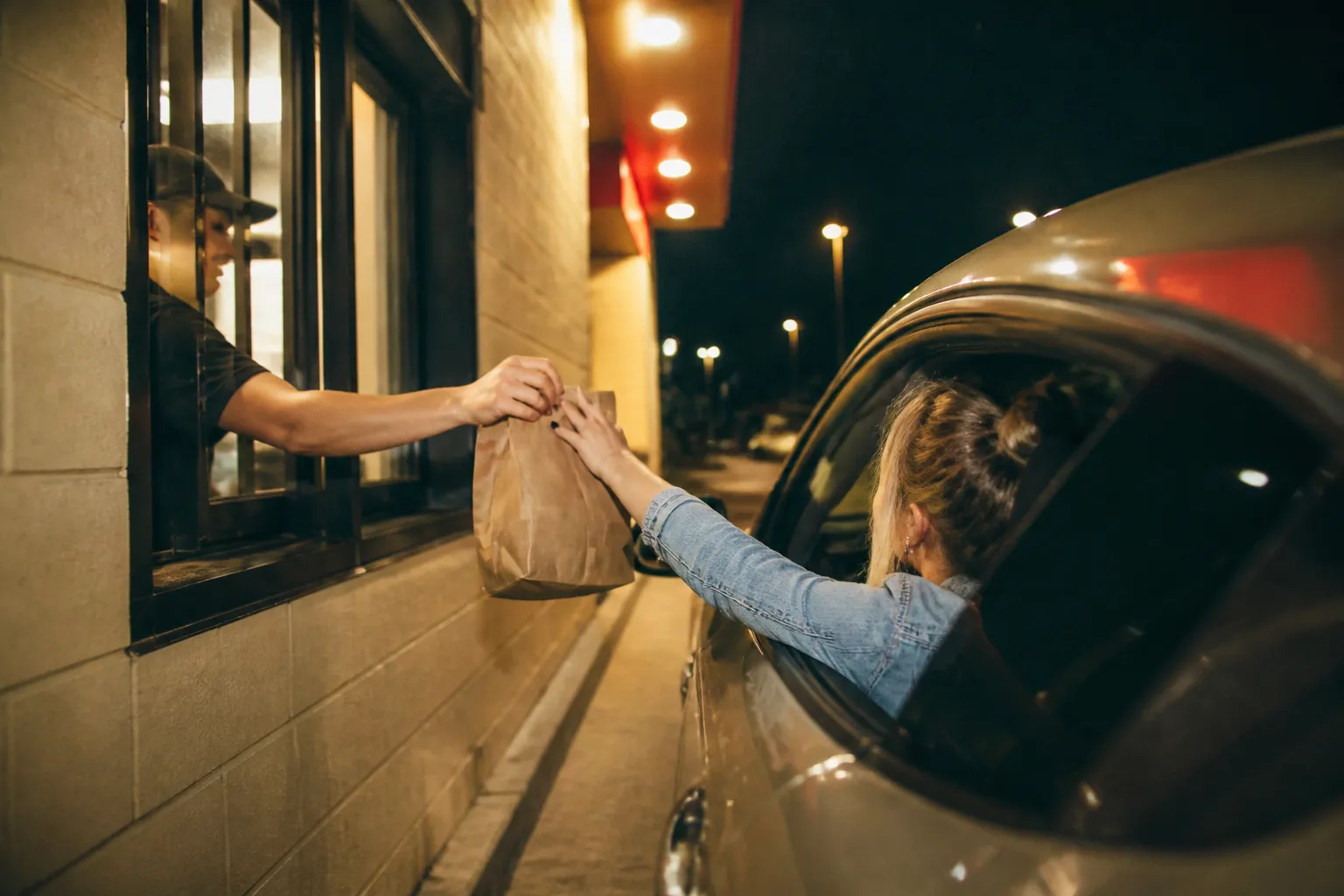A drive-thru lane glowing softly against the dark night sky