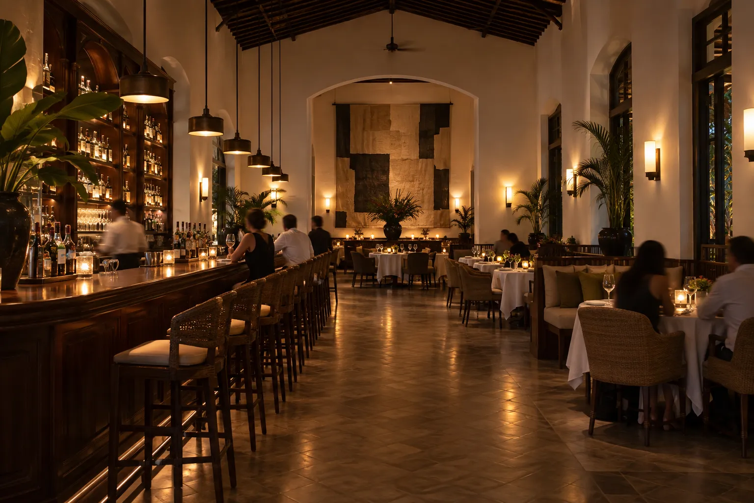 A high-ceilinged modern restaurant dining room with a long bar and warm lighting