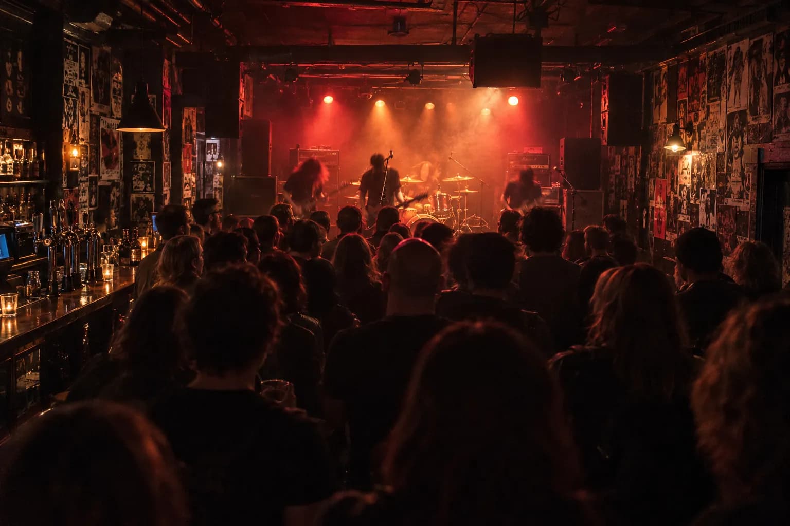 A small dark music club with a low stage and a band playing to a close crowd