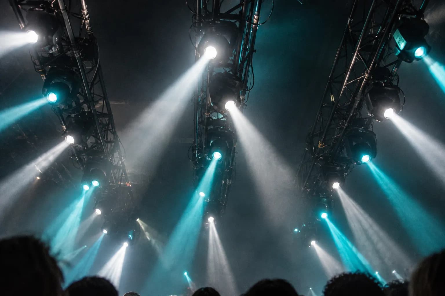A focused club dance floor close to a low DJ booth under hard light