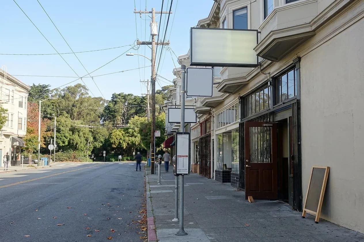 A San Francisco commercial street on a bright Saturday morning, low pub and shop frontages along one side, the road climbing gently into the distance