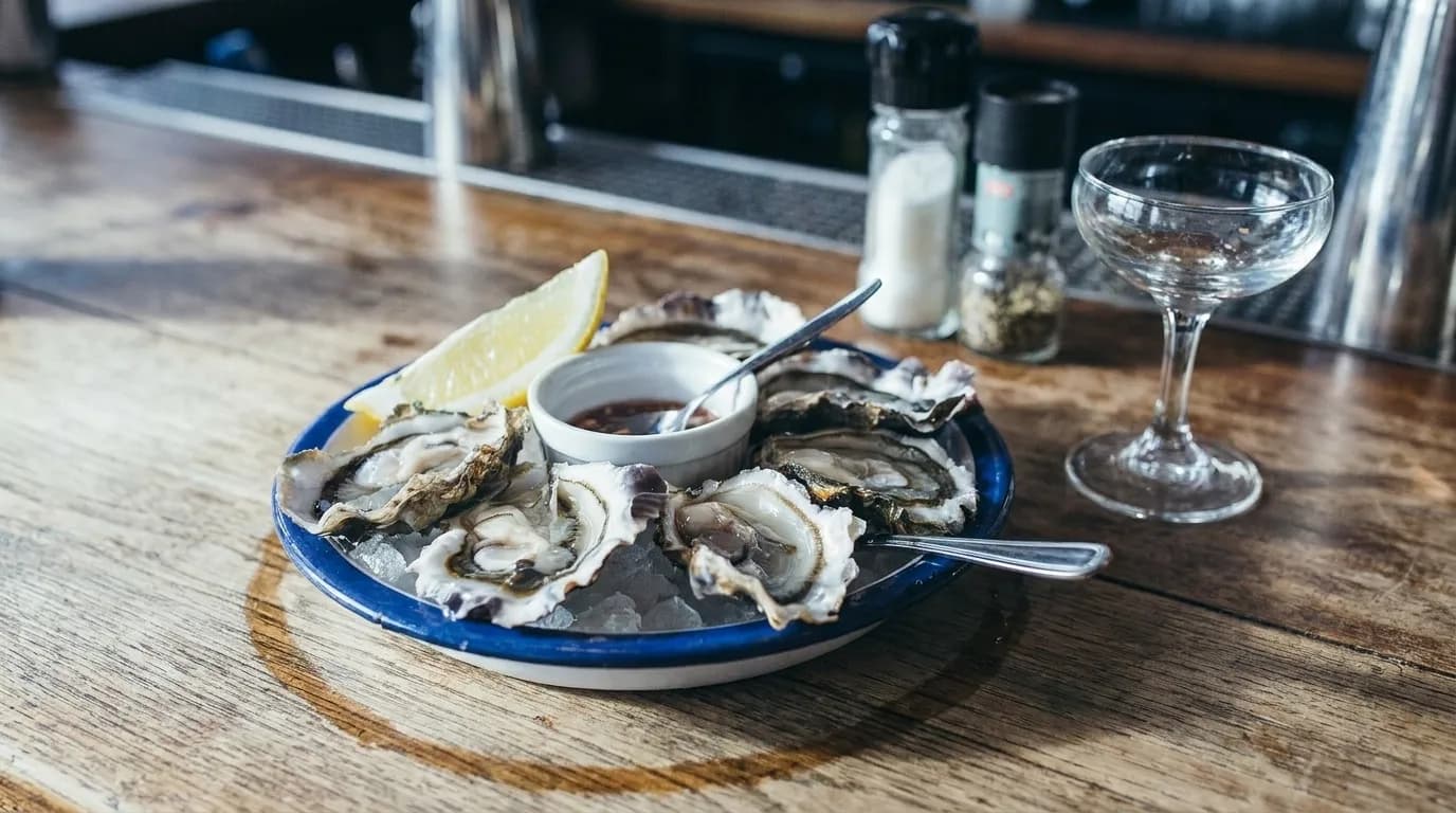 Oysters on ice with a coupe glass on a bar counter