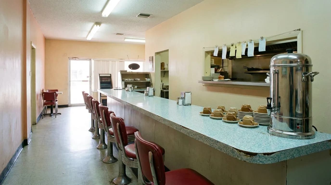 A lunch counter interior with stools and a service pass