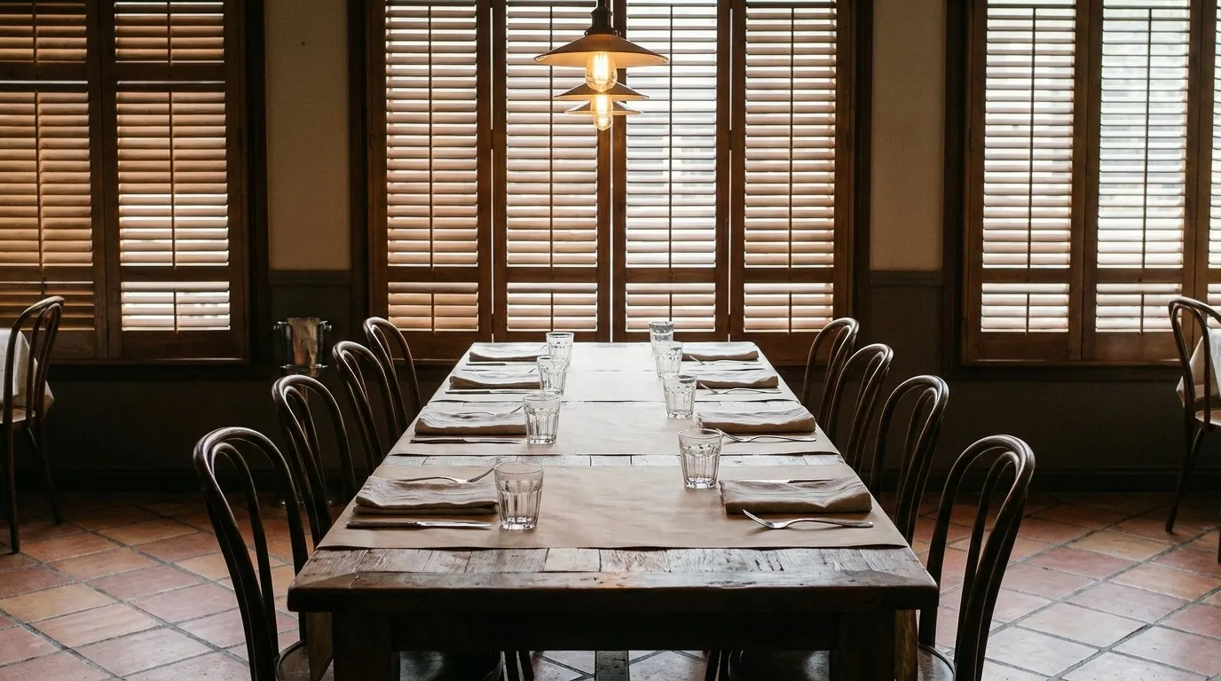 A long dining table set for a large group in a restaurant