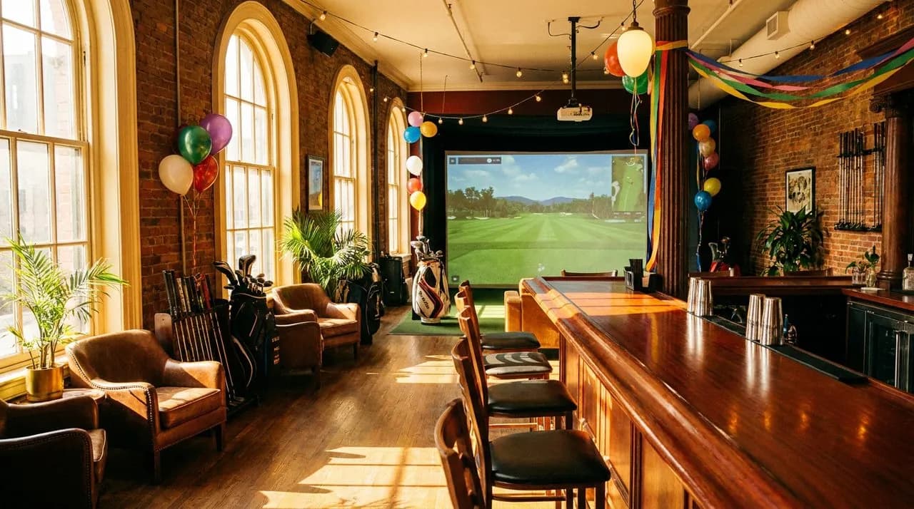 Murray Hill golf simulator bar with tall windows, polished counter, and projector screen showing a generic fairway on a bright afternoon.