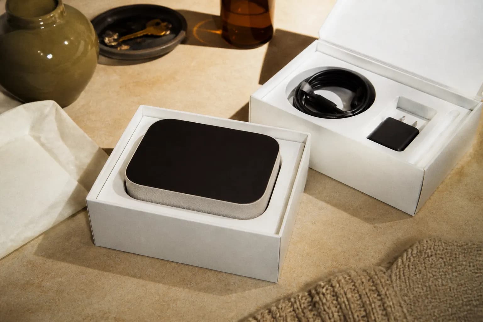 An opened electronics box with the product sitting on a table beside its packaging