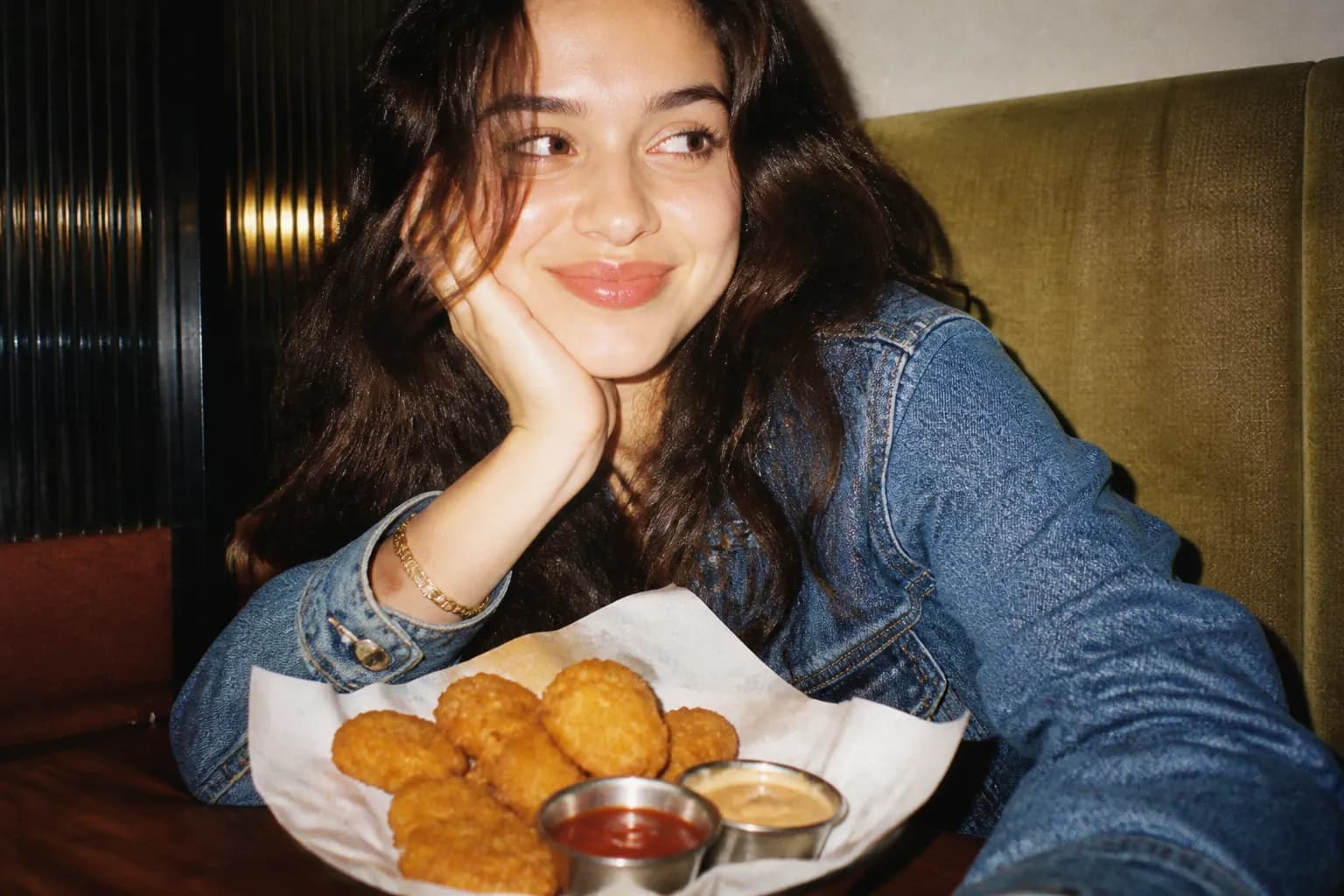 Small dipping sauce cups arranged beside a serving of golden chicken nuggets