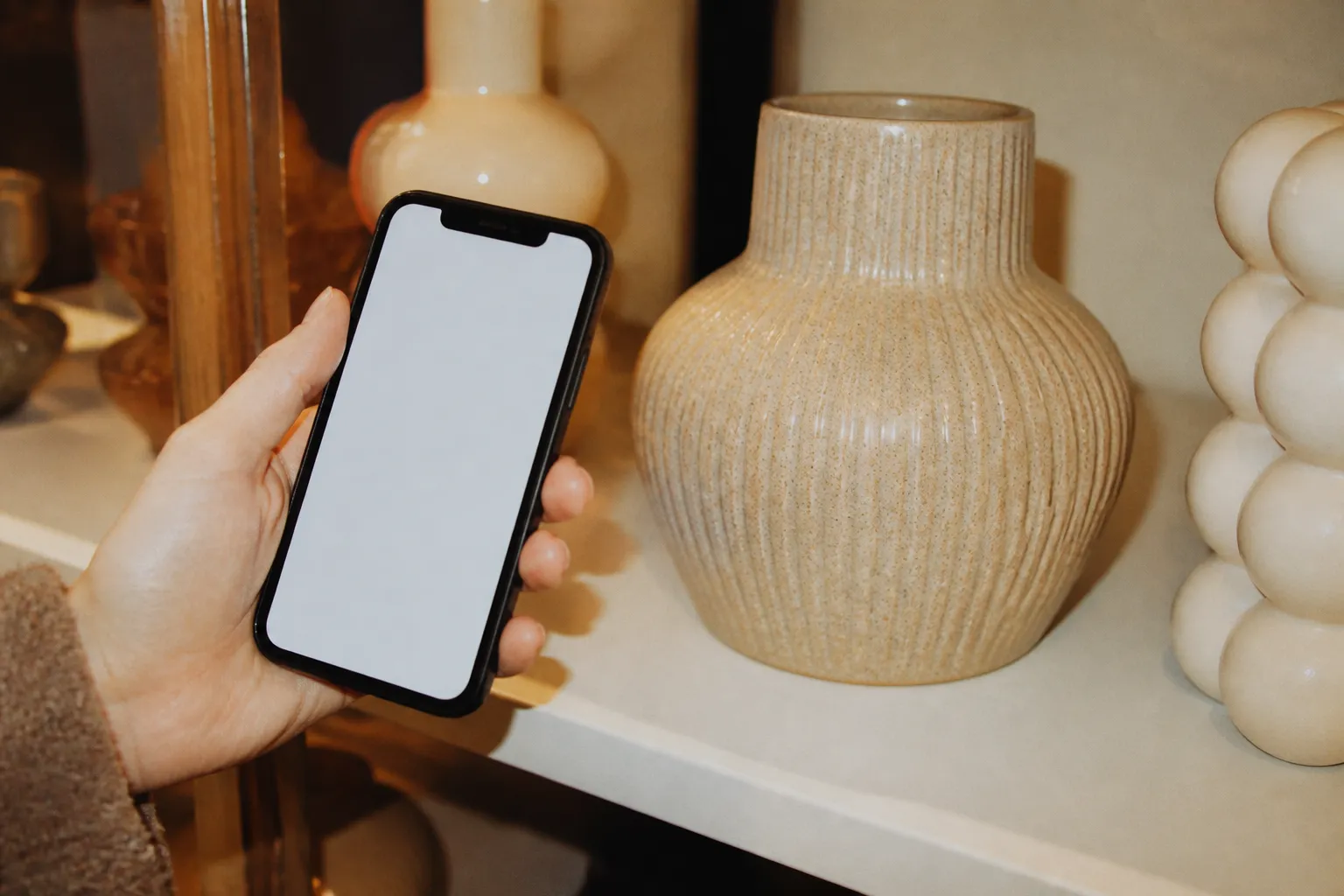 A phone showing a price displayed next to a product on a store shelf