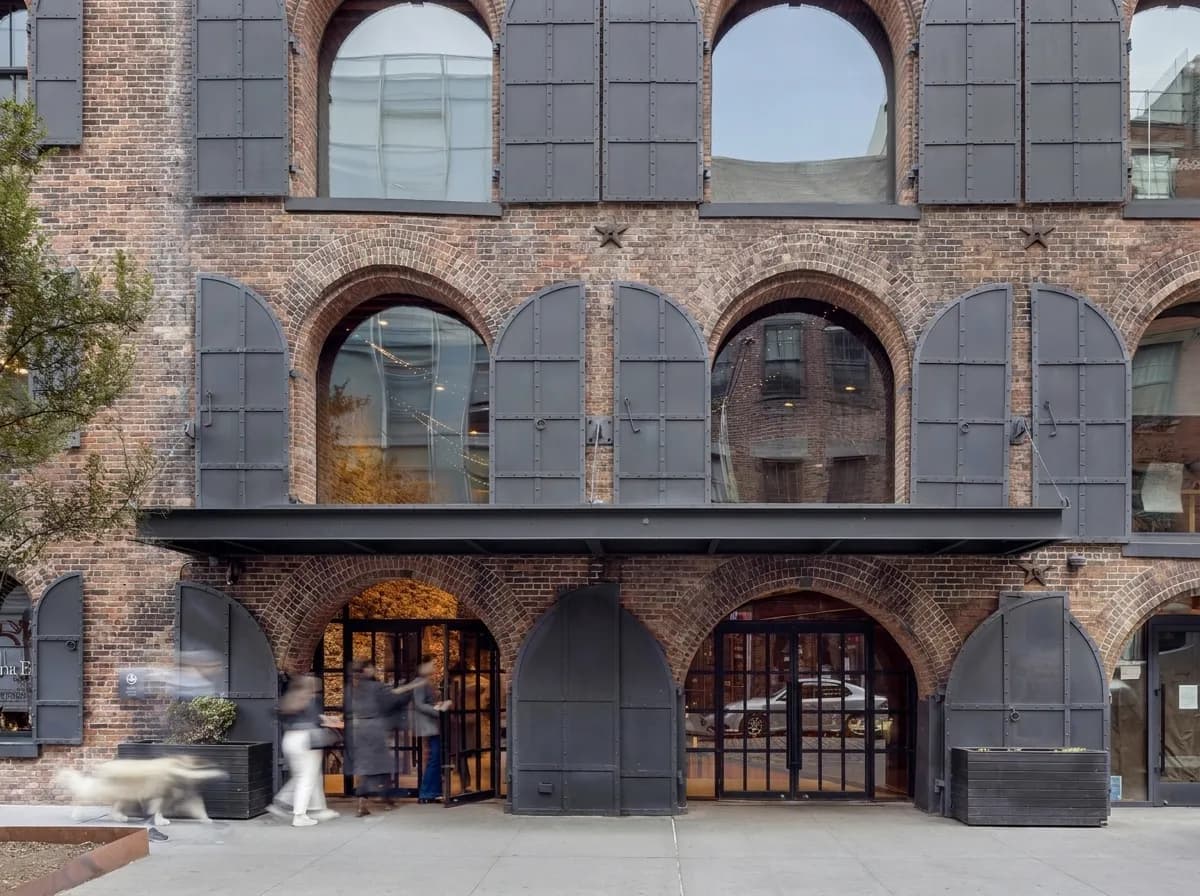 Arched brick facade and iron shutters of the 19th-century Empire Stores warehouse that houses Time Out Market in Dumbo, Brooklyn