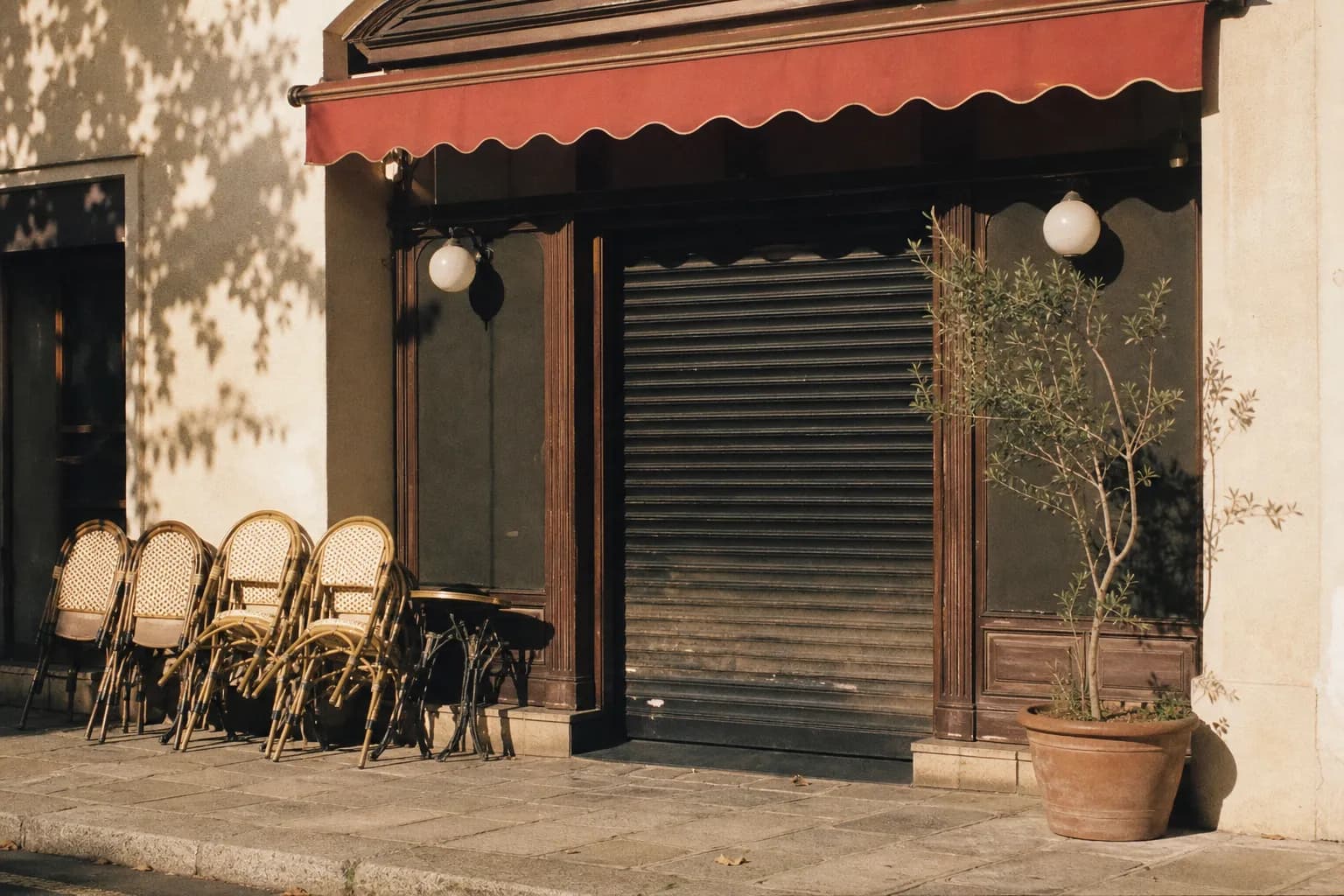 A closed restaurant storefront with dark windows on a quiet, empty Sunday street