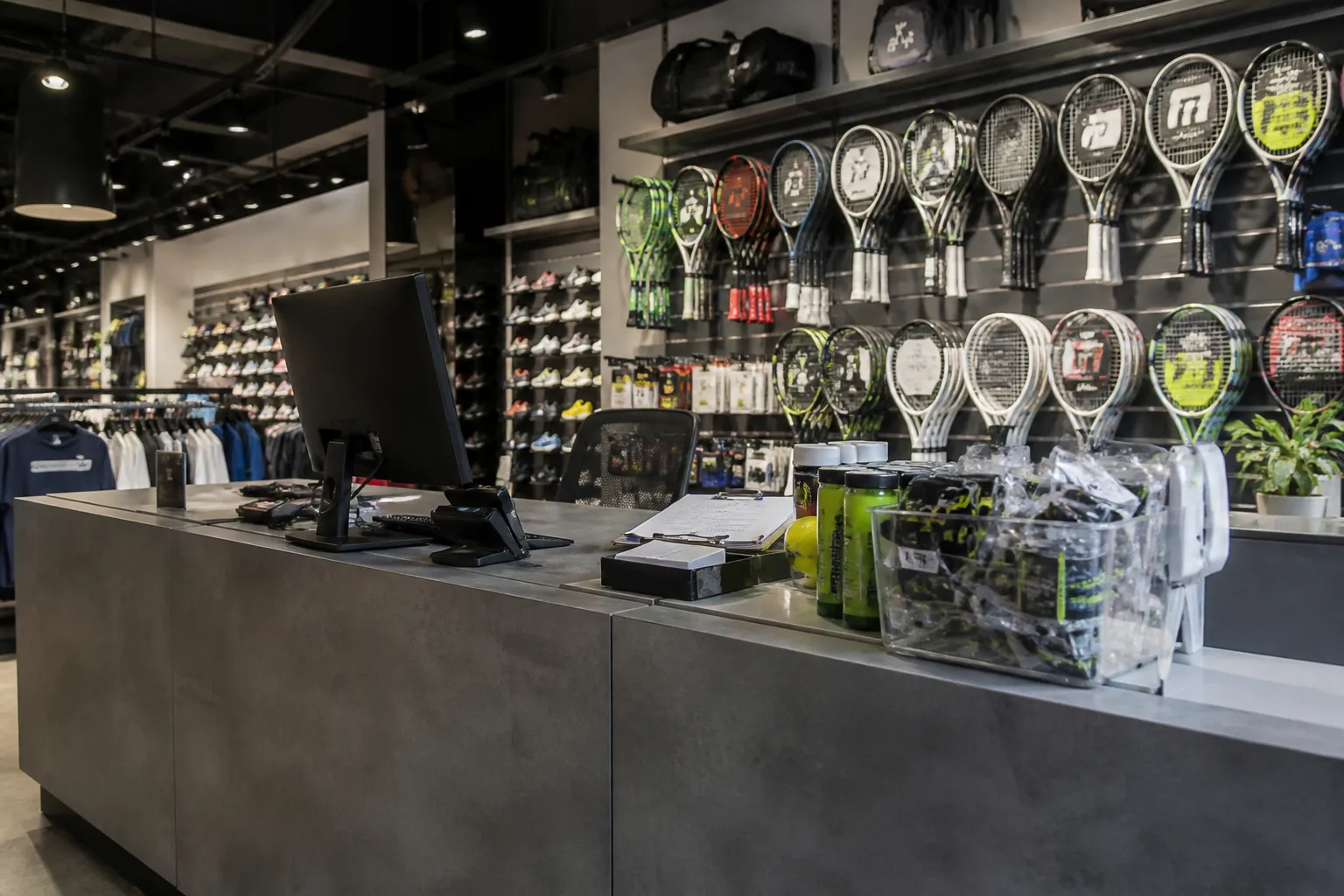 A modern, bright interior service counter at a sporting goods retail center with organized shelves of gear and athletic equipment in the background.