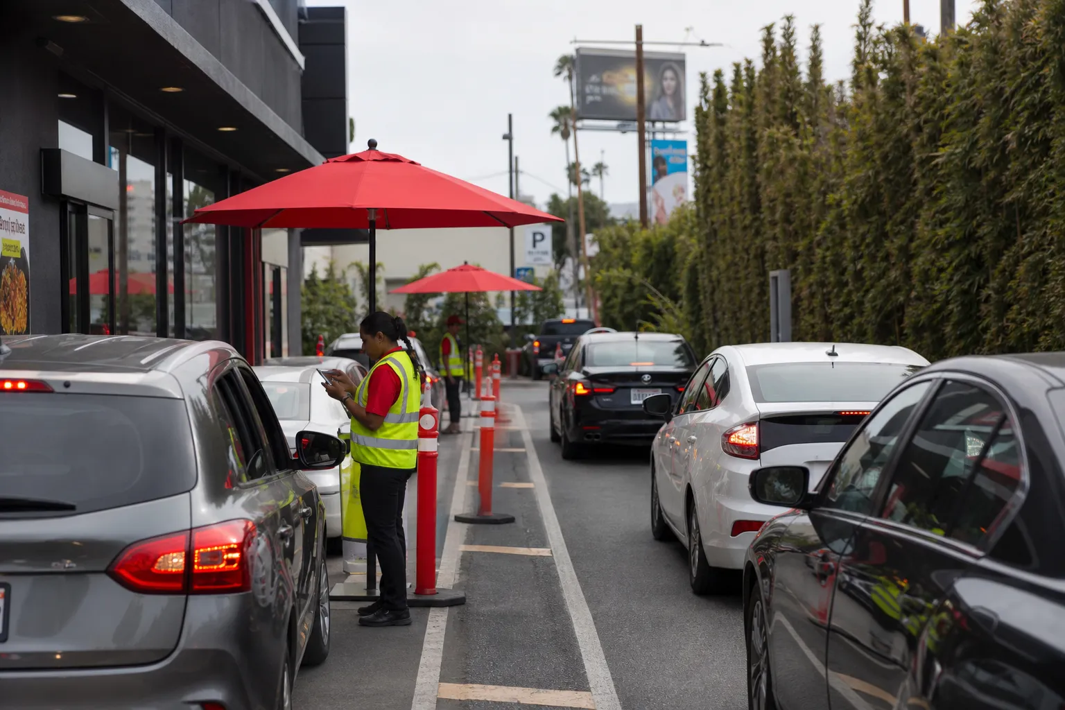 Busy double drive-thru lanes at Chick-fil-A on Santa Monica Boulevard with outdoor order takers.