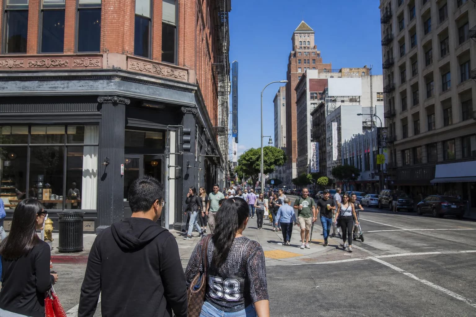 Pedestrians walking along a busy street in the Historic Core neighborhood of Downtown Los Angeles