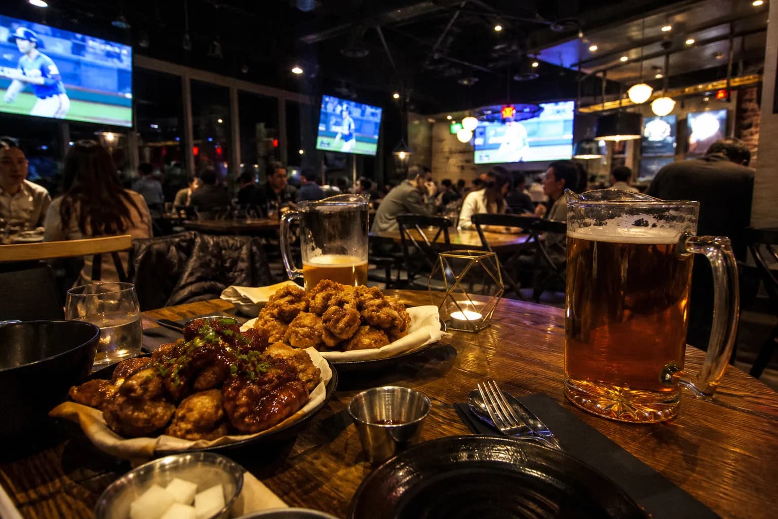 A lively sports bar setup in Koreatown, Los Angeles, with beer and Korean fried chicken.