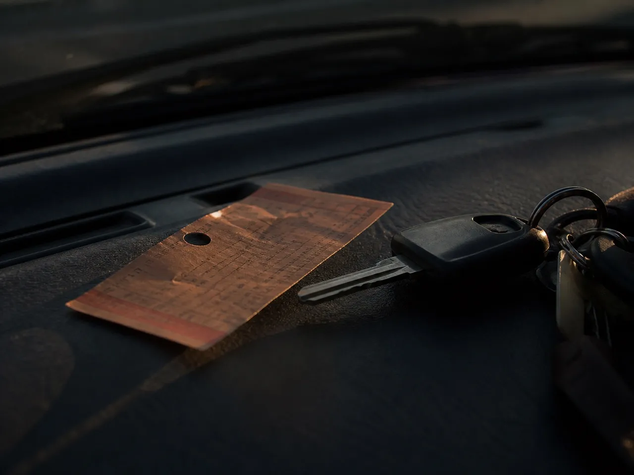 Cinema ticket and keys on a car dashboard before an early drive