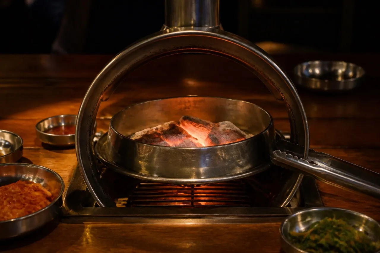 Tabletop grill set into a timber table with the room dark behind it