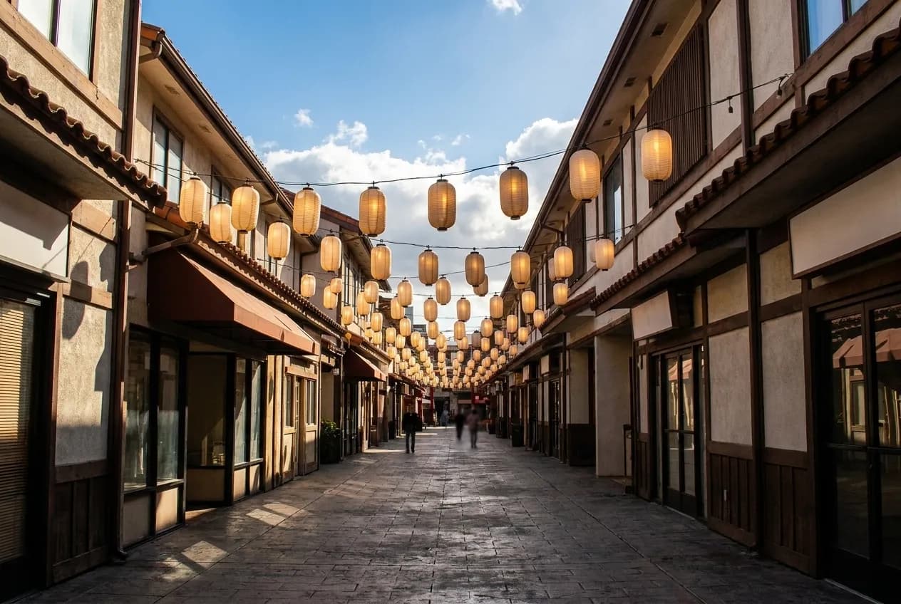 A pedestrian plaza in Los Angeles with a tower, lanterns and low shops