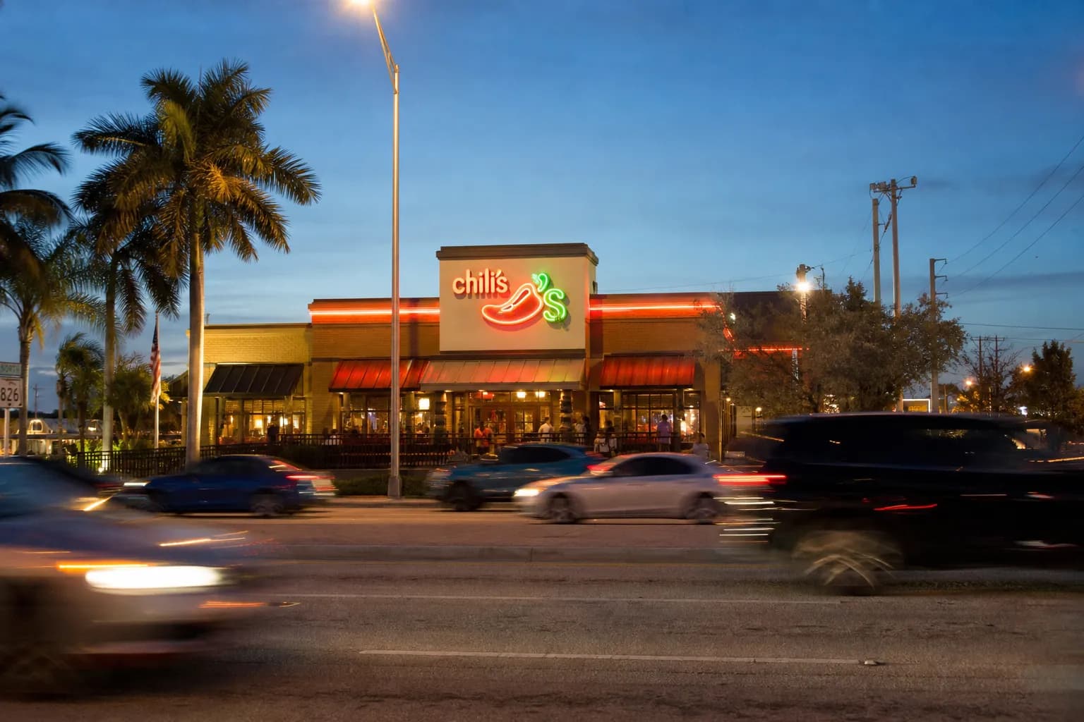The neon-lit exterior of the Chili's on Bird Road in Miami at dusk.