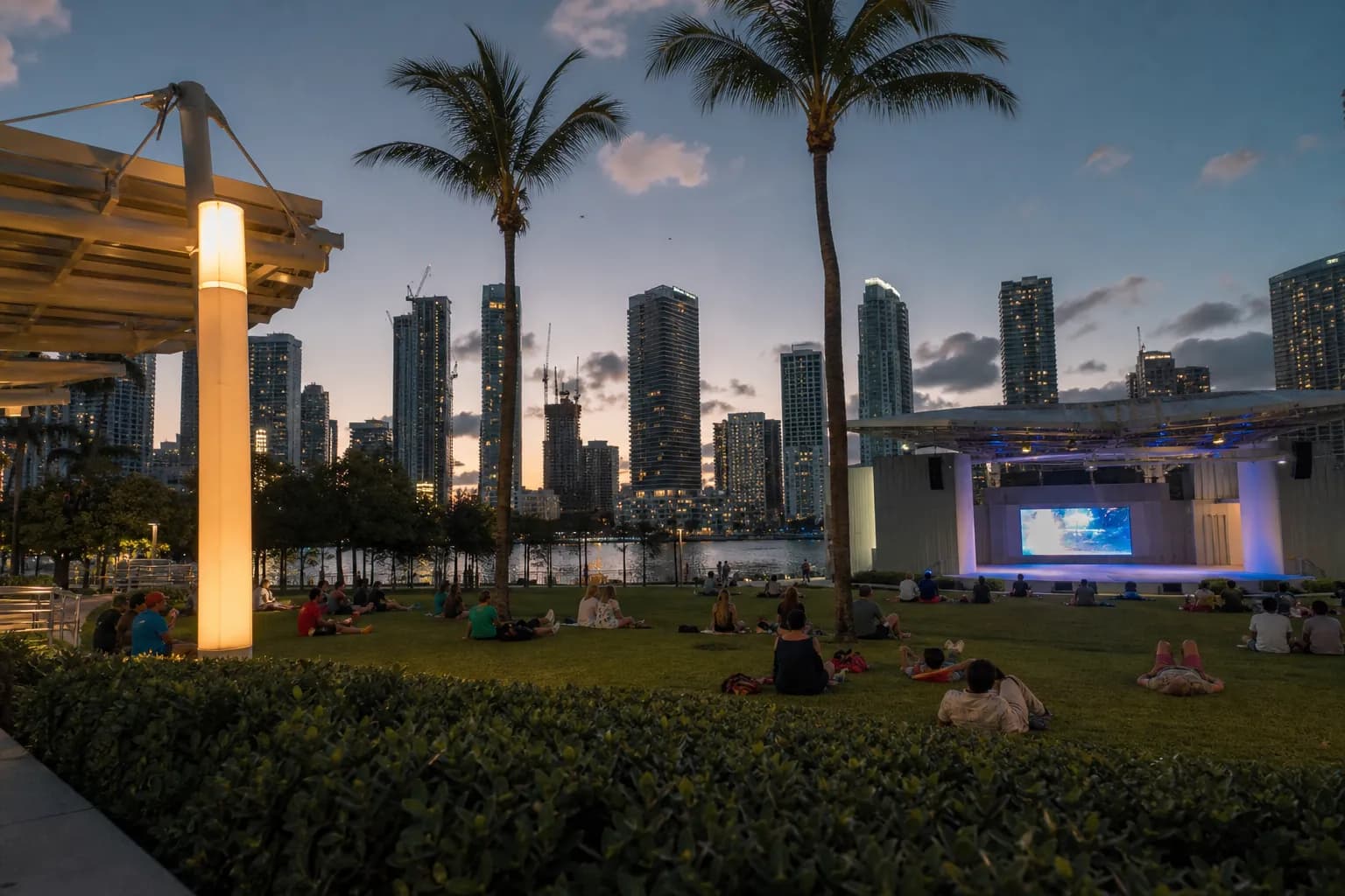 The grassy lawn at FPL Solar Amphitheater with the Downtown Miami skyline at twilight