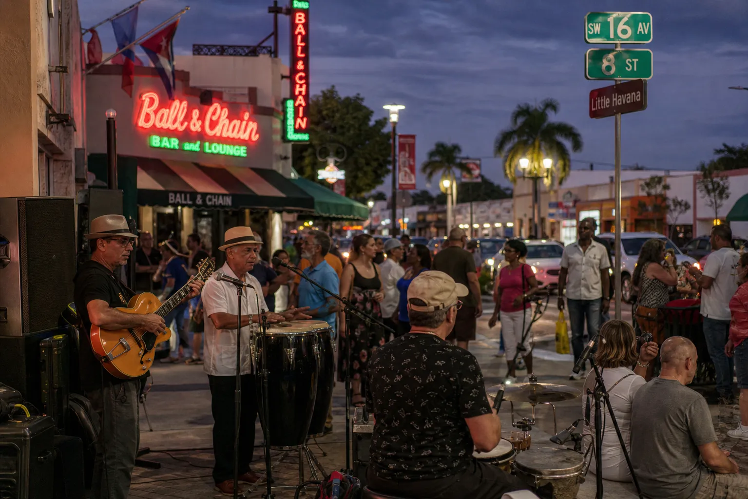 Musicians performing on a lively street corner on Calle Ocho during Viernes Culturales in Miami.