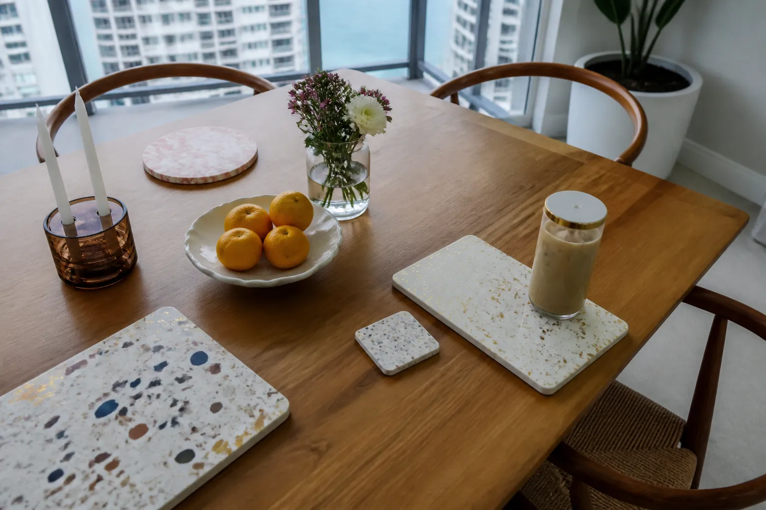 A styled wooden craft table displaying colorful polymer clay blocks, gold leaf sheets, and a sealed iced coffee cup on a rainy afternoon.