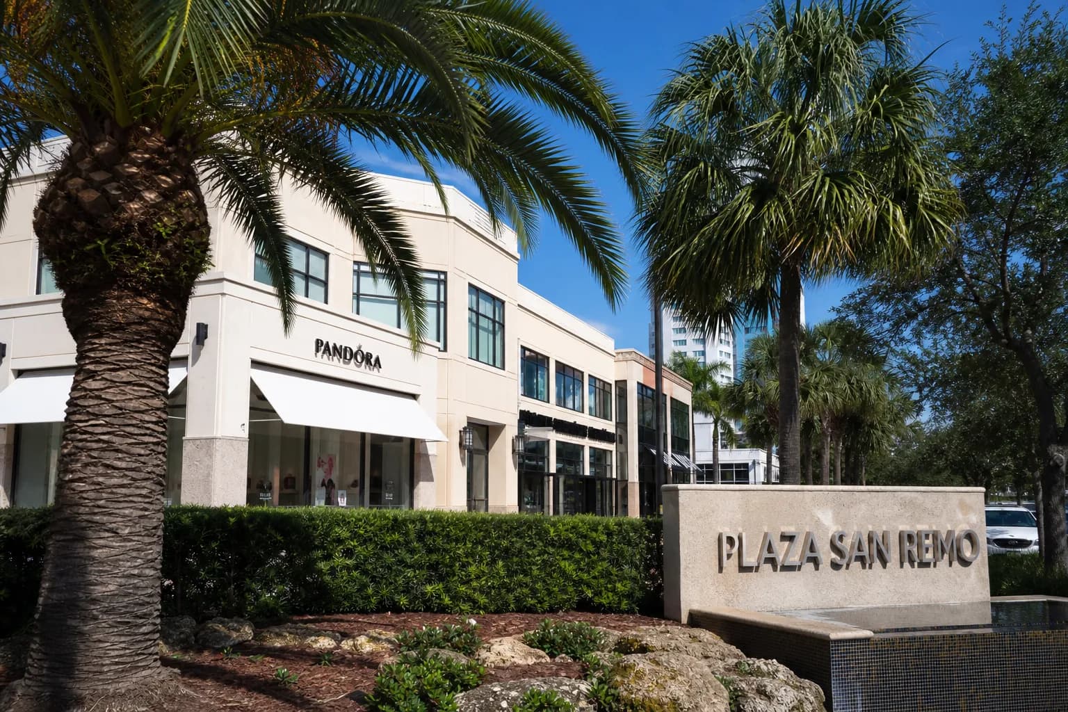 The modern storefront exterior of Plaza San Remo shopping complex in Miami