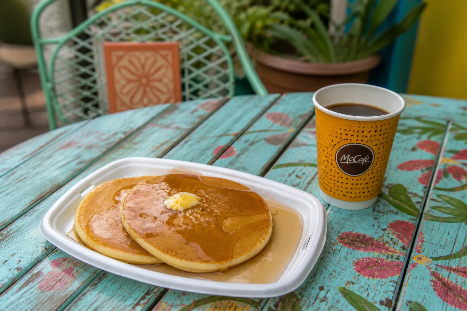 A flat lay of McDonald's hotcakes and coffee on a pastel table in Little Havana, Miami.