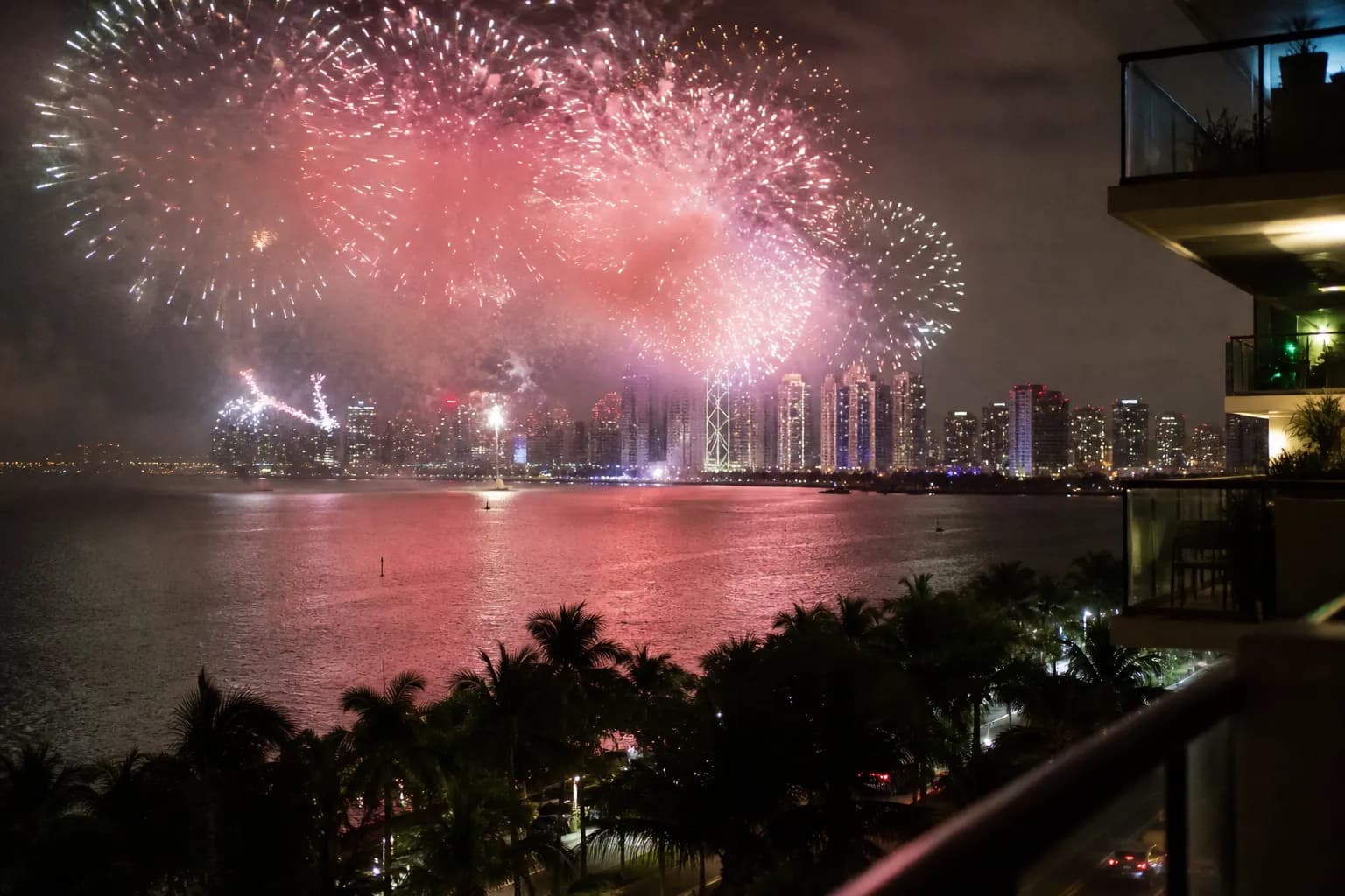 Colorful fireworks exploding over the Miami skyline as seen across Biscayne Bay from South Beach.