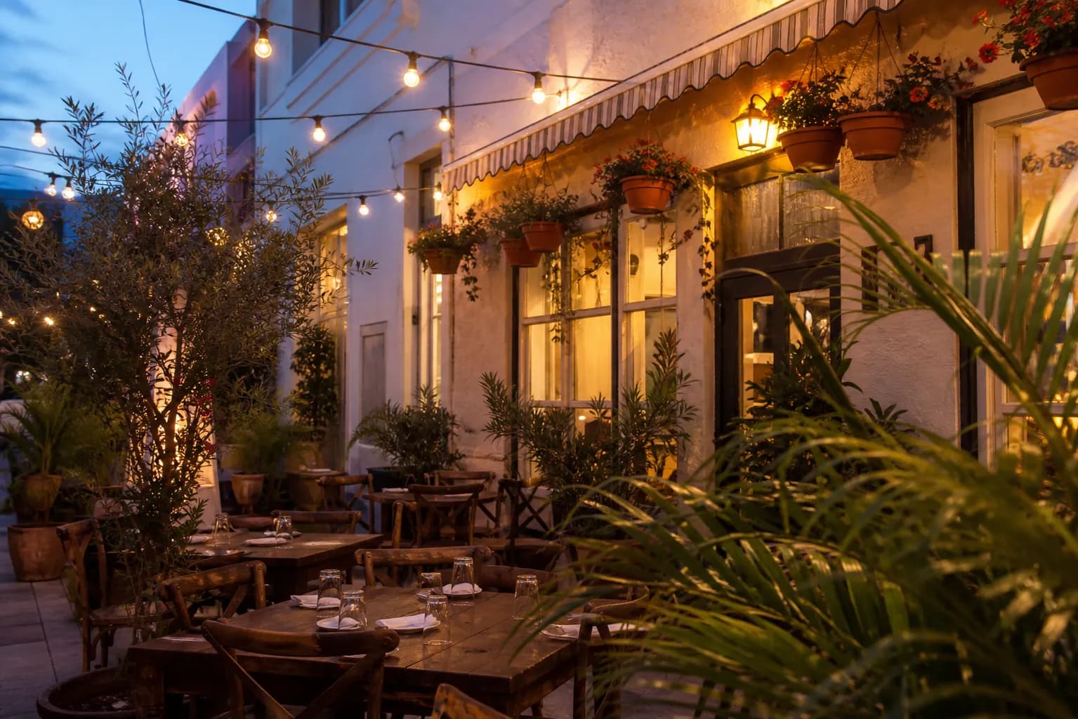 Cozy South Beach Italian bistro outdoor patio with string lights and wooden tables at dusk.