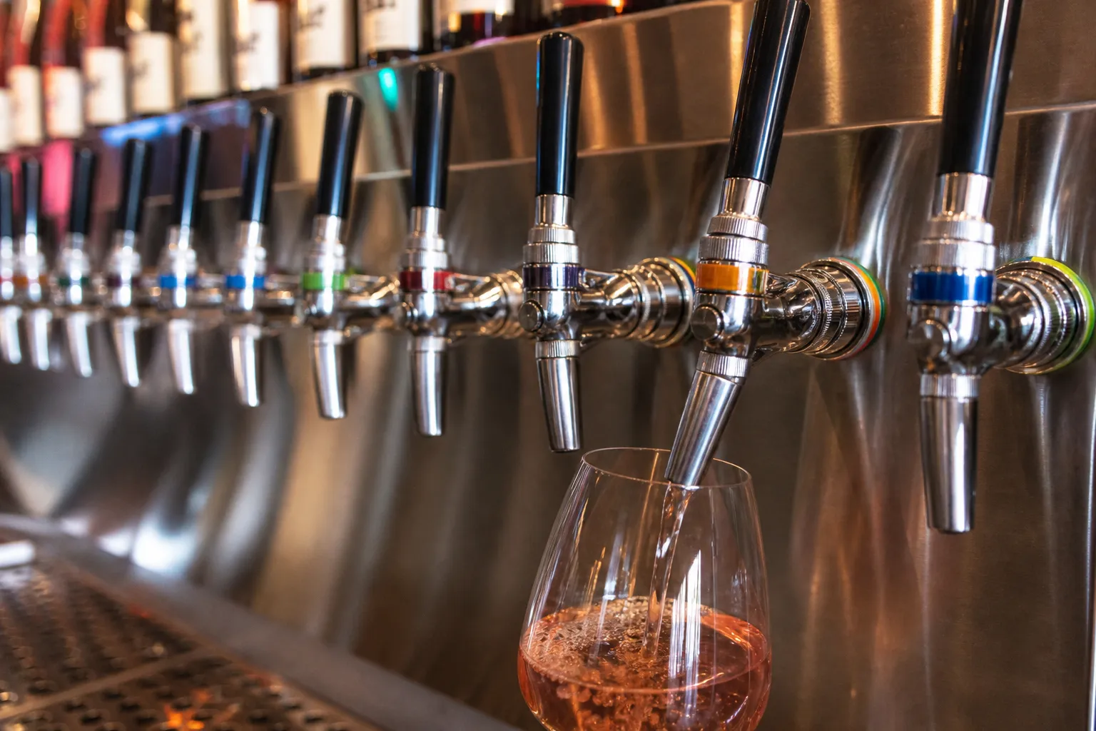 A close-up shot of wine pouring from a tap at Sixty Vines Miami.