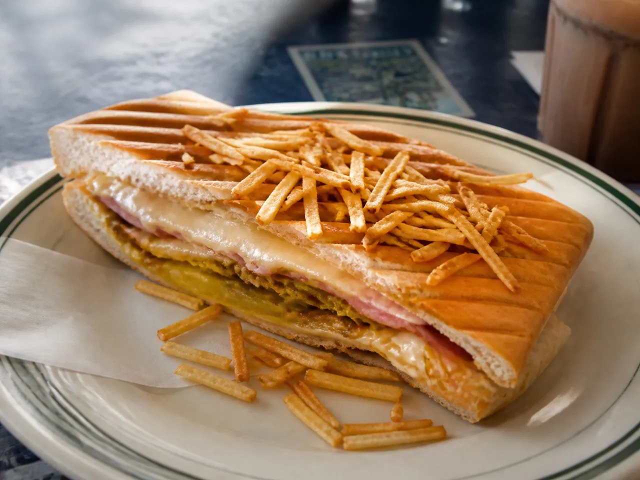 Pressed Cuban sandwich cut on the diagonal on a plate at a Miami counter