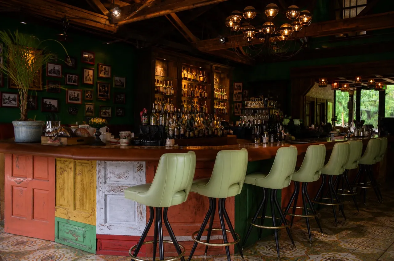 Small Miami bar interior with a counter, stools and warm lighting