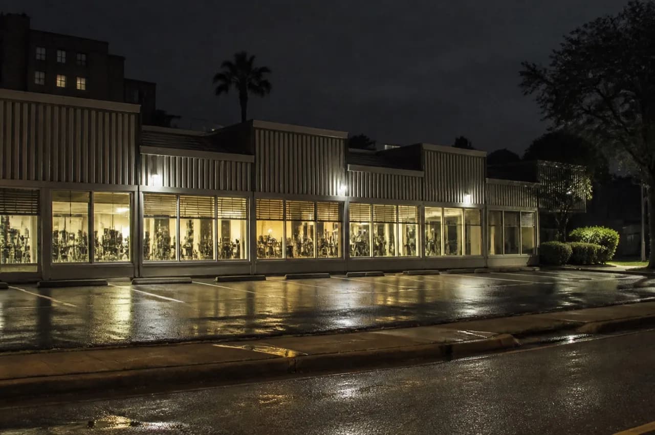Low Miami gym frontage lit from inside at night