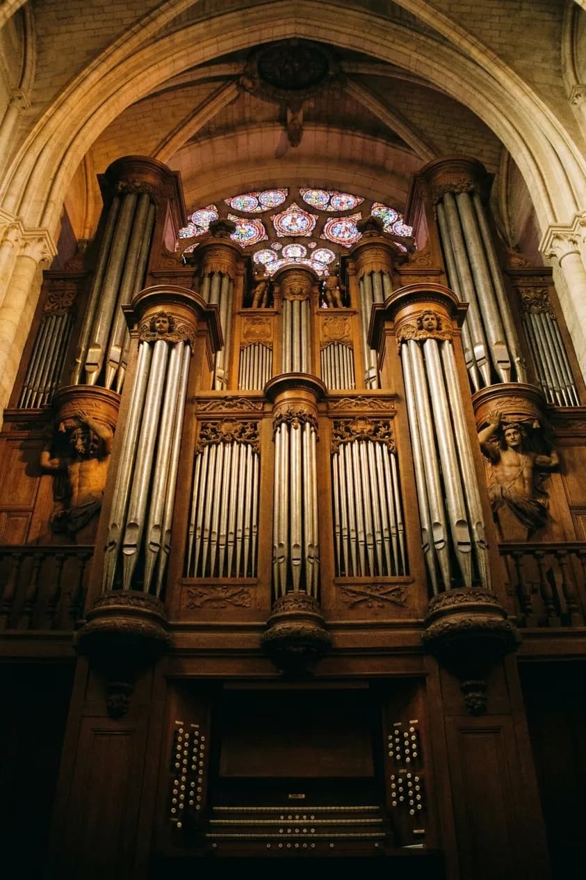 A grand pipe organ with ranks of metal pipes rising above a console