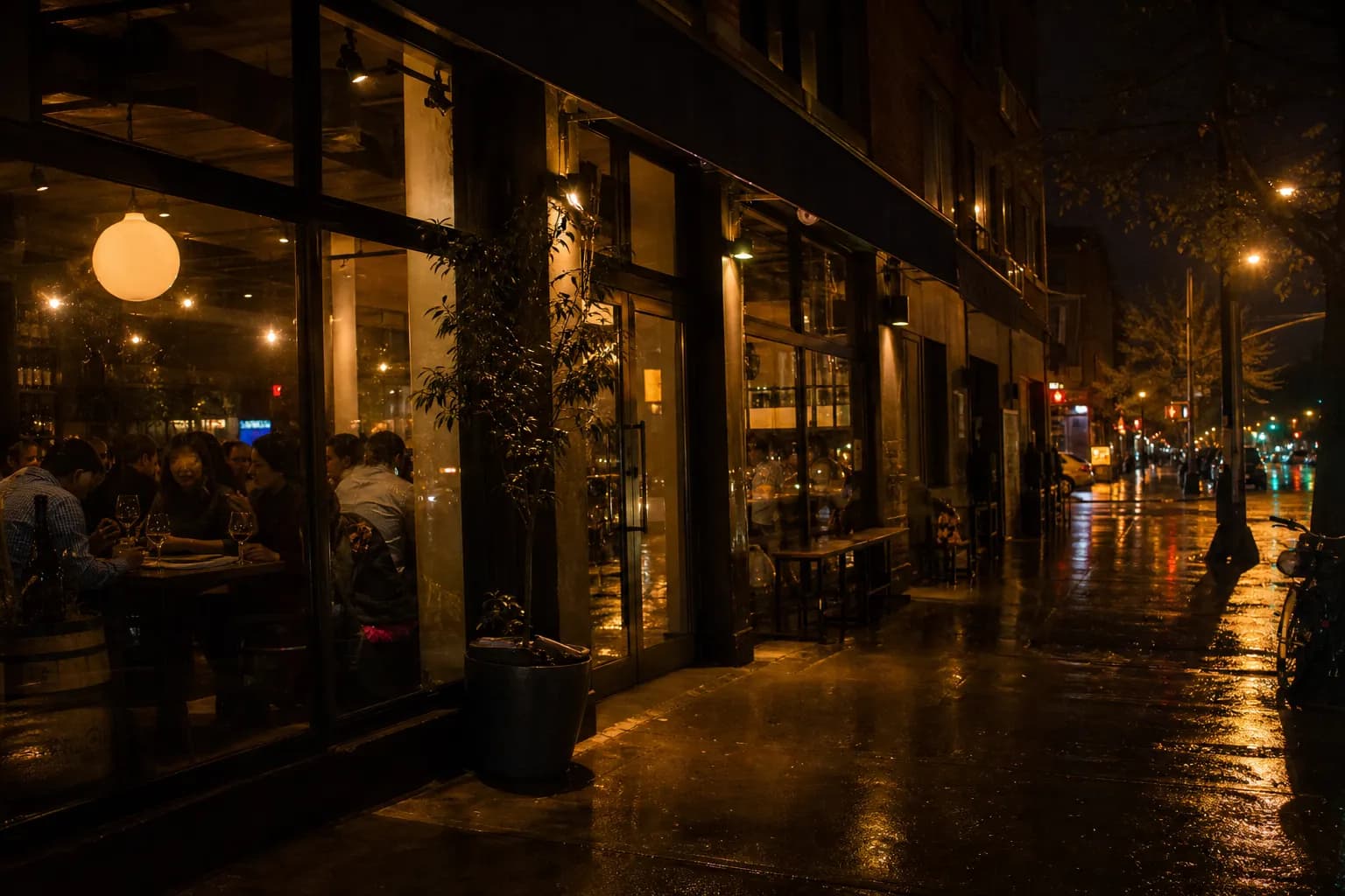 The warm, inviting brick exterior of Barcelona Wine Bar in Brooklyn on a bustling evening, with soft light spilling onto the sidewalk.