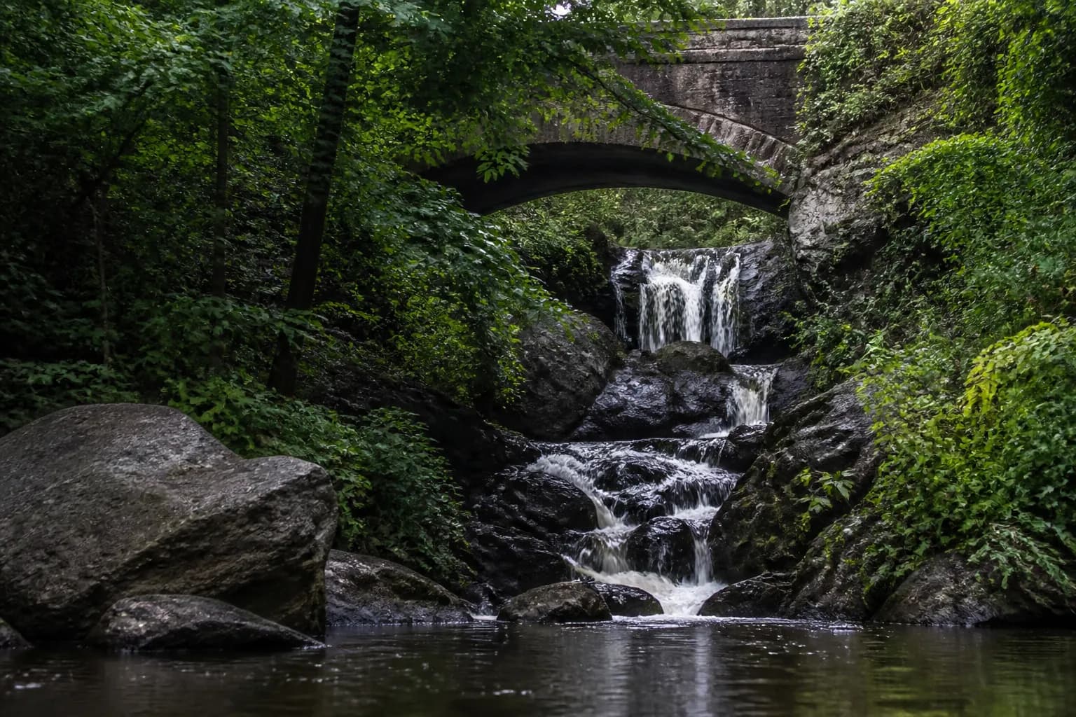 A hidden waterfall cascading under Glen Span Arch in the North Woods of Central Park.