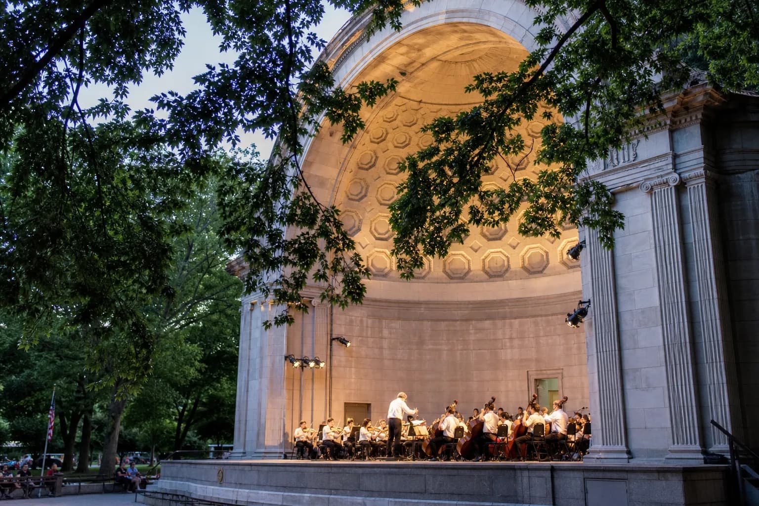 Musicians performing classical music under the lights of the historic Naumburg Bandshell in Central Park.