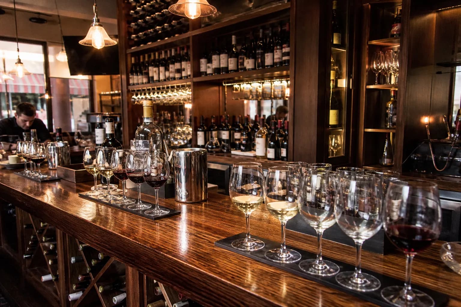 A polished wooden tasting bar lined with wine flights and glasses at Cooper's Hawk.