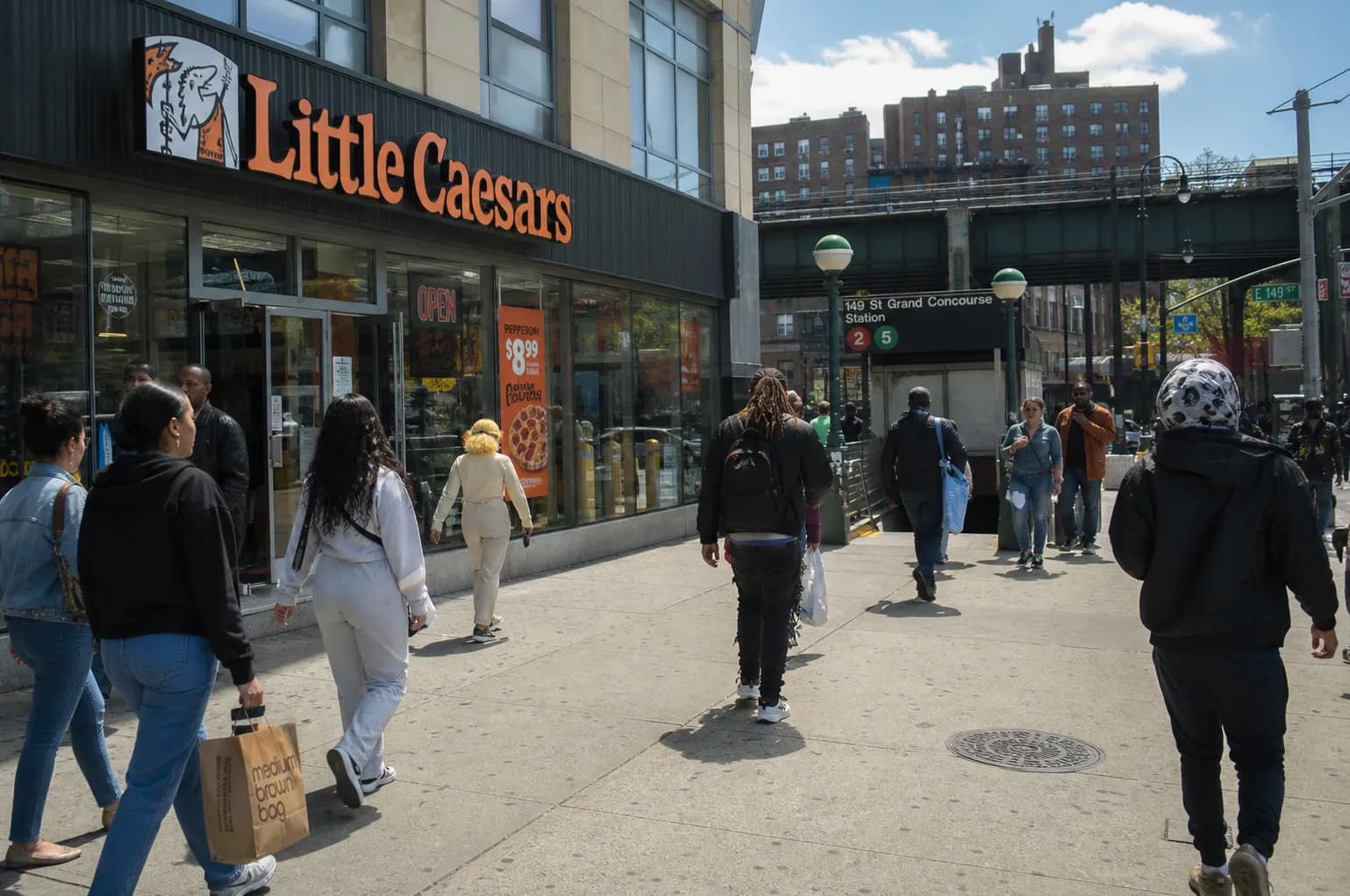 The exterior storefront of the busy Little Caesars location near the 149th Street Hub subway station in the Bronx.