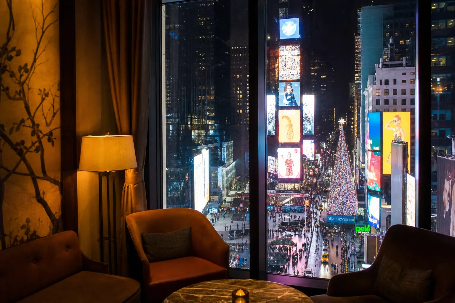 A view of the illuminated Times Square streets seen from the warm interior window of an upscale NYC lounge.