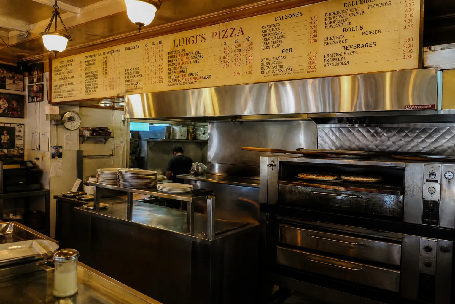 Inside a traditional Brooklyn slice shop with retro signage and fresh pizzas behind a glass counter.