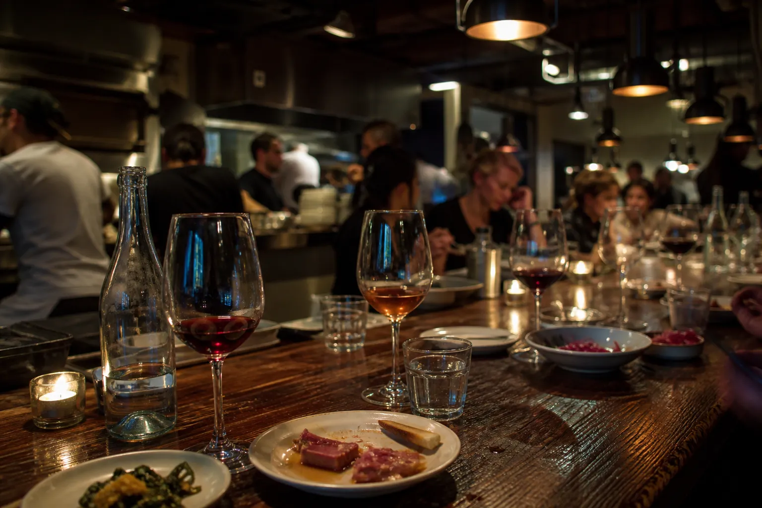 A cozy bar counter inside a Lower East Side restaurant featuring wine and small plates under warm lighting.