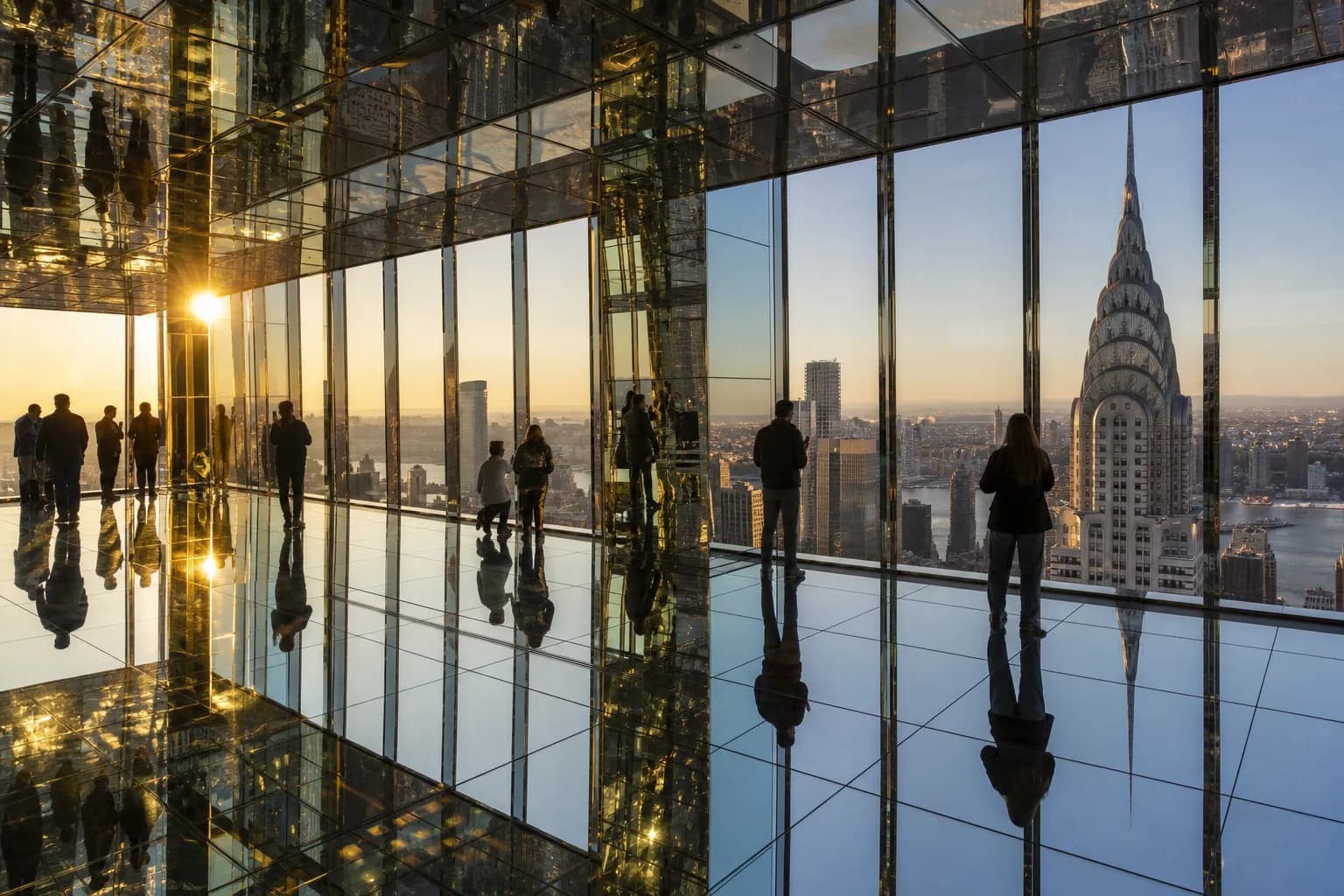 The mirrored interior of the Air gallery at Summit One Vanderbilt reflecting the Midtown Manhattan skyline at golden hour.