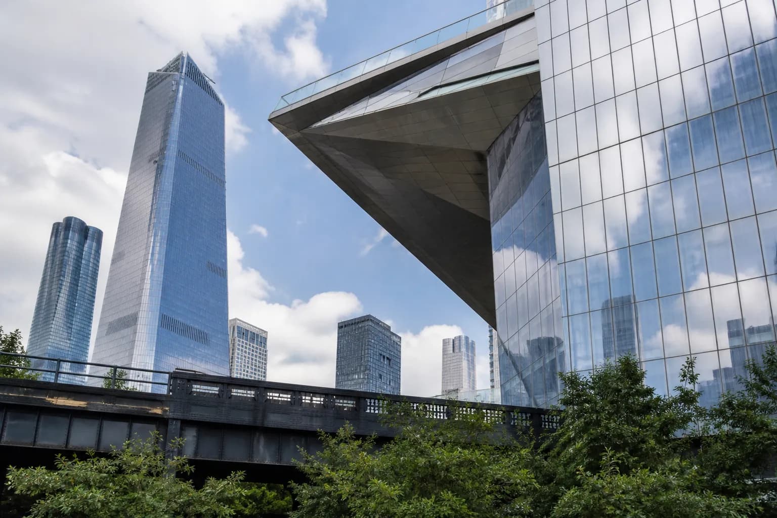 The angular, metallic structure of The Edge NYC observation deck seen from the High Line trail below.