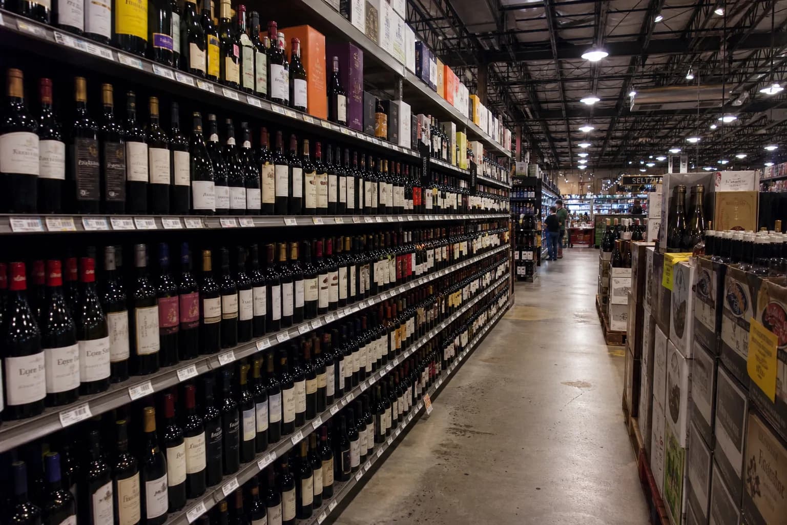 Long aisle of a warehouse-style wine store filled with rows of bottled wines.