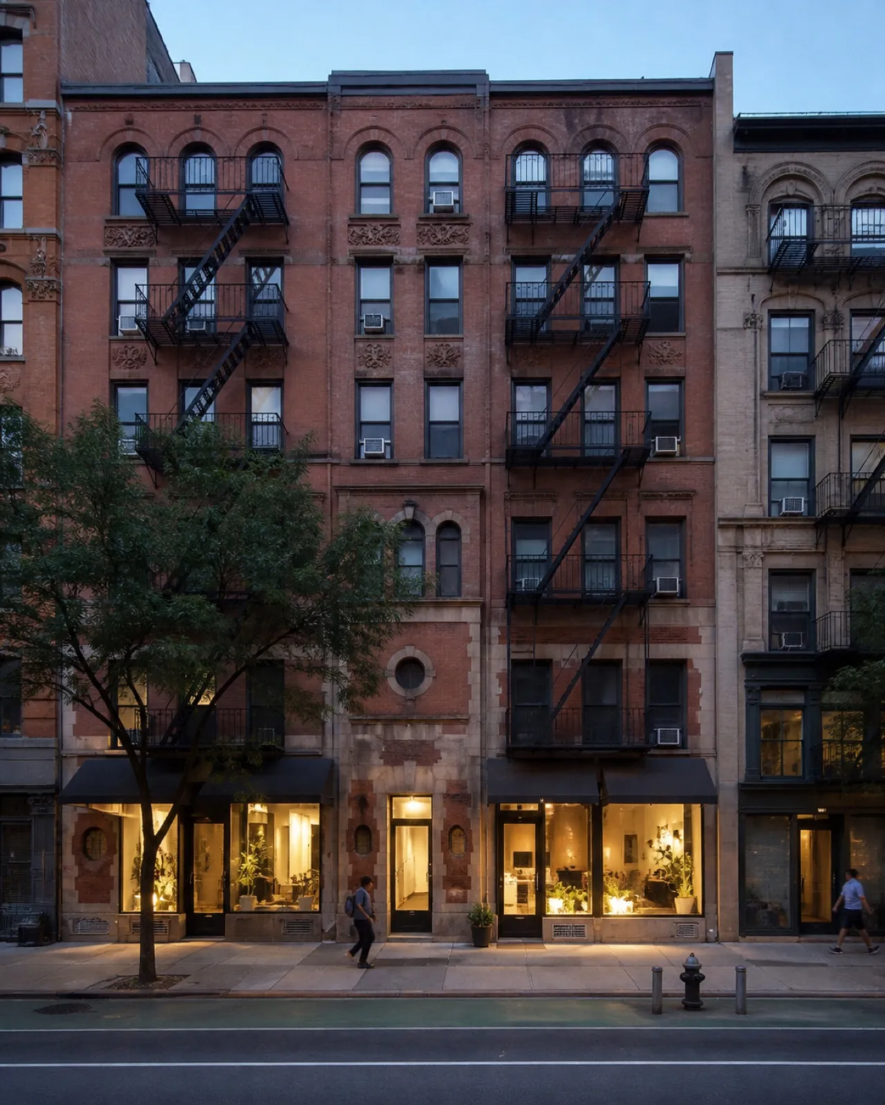 East Village tenement block with ground-floor storefronts under evening light