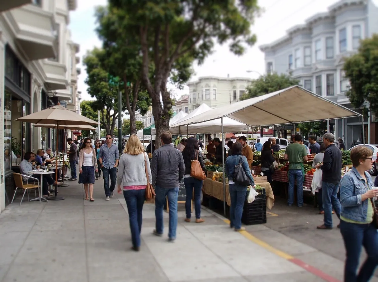 Visitors gather on Patricia's Green lawn with Hayes Valley storefronts in the background, San Francisco