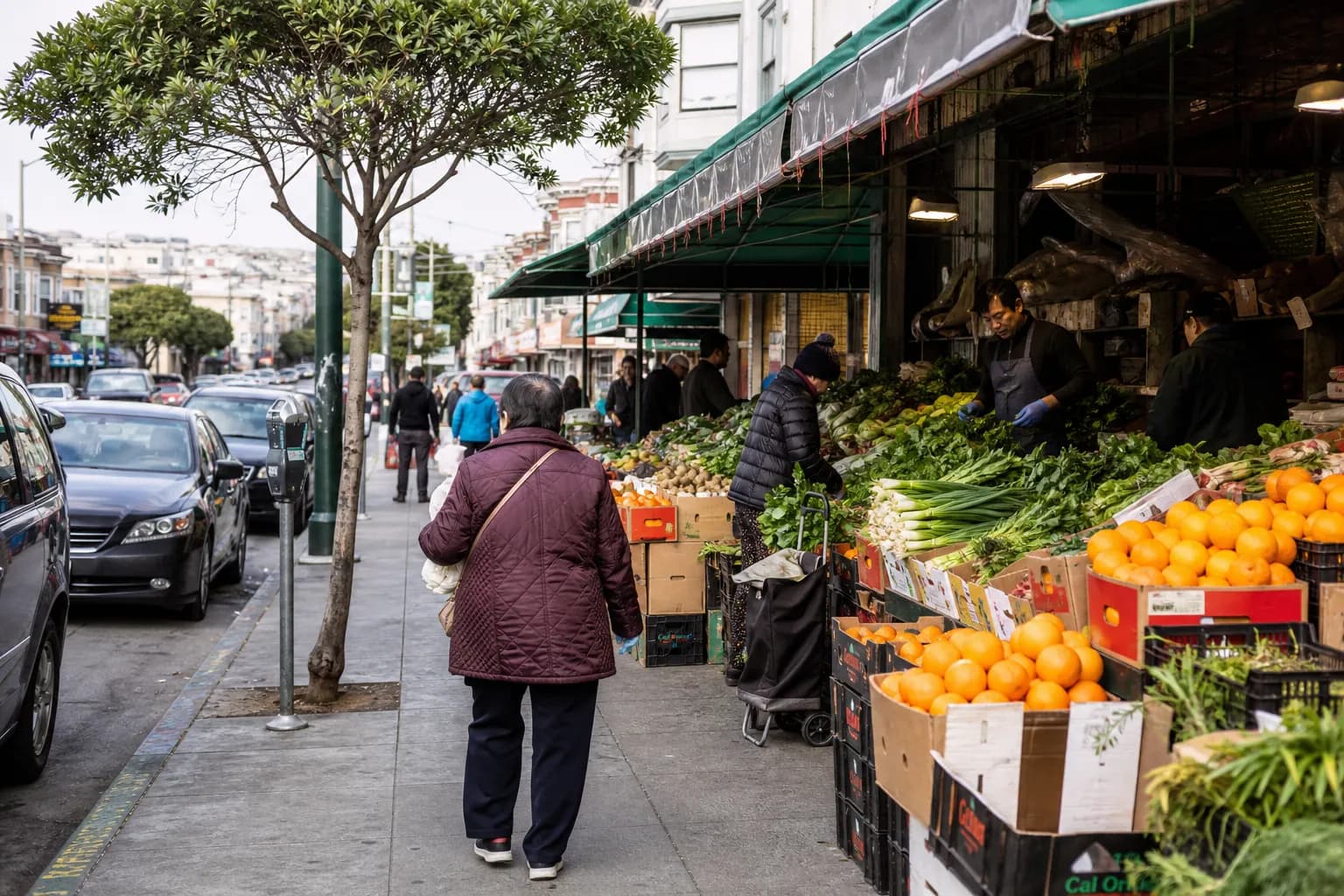 A wide-angle view of shoppers browsing fresh, affordable produce at an open-air market on a sunny afternoon in San Francisco's Richmond District